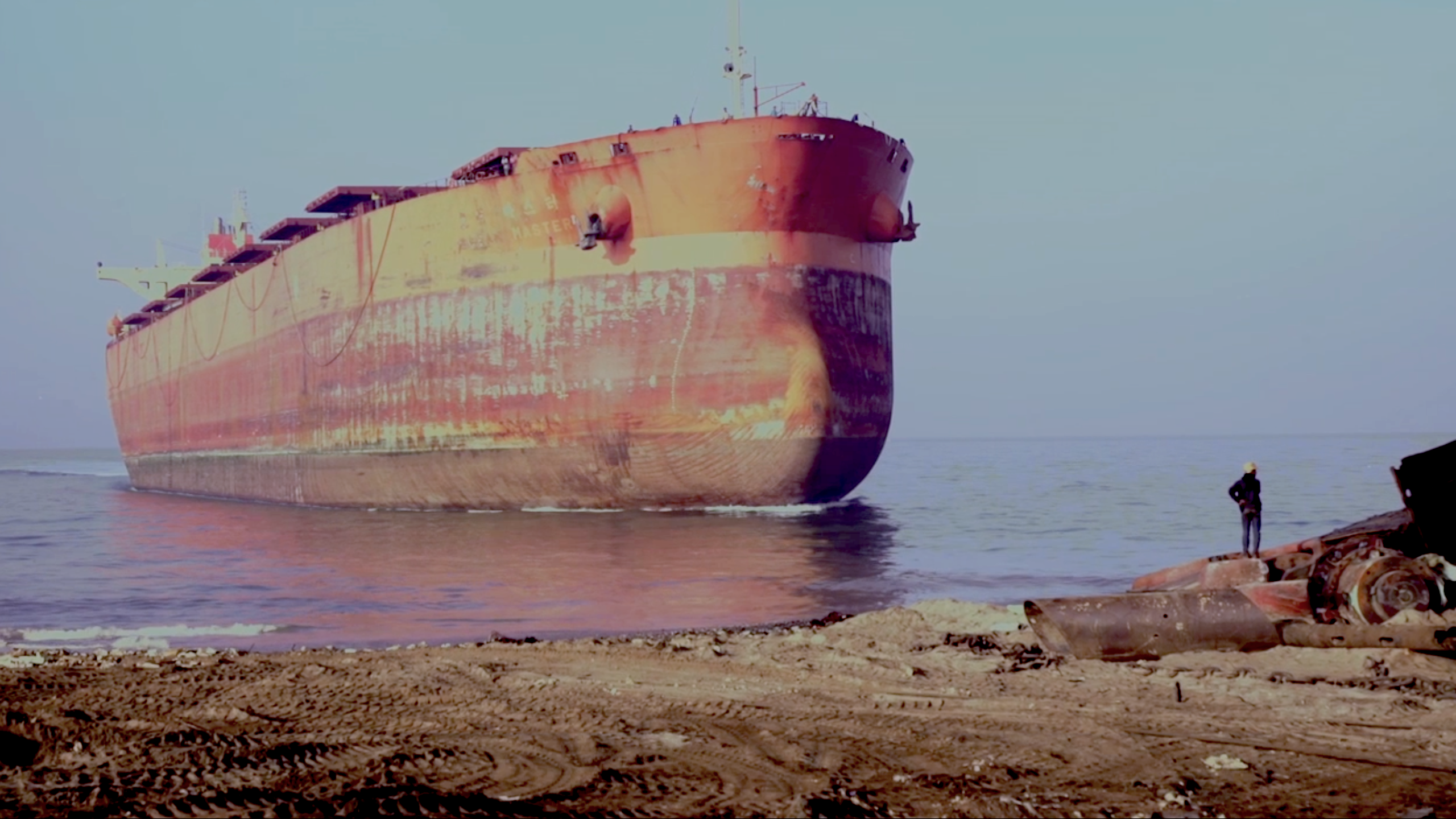 Image of a rusted ship beached.