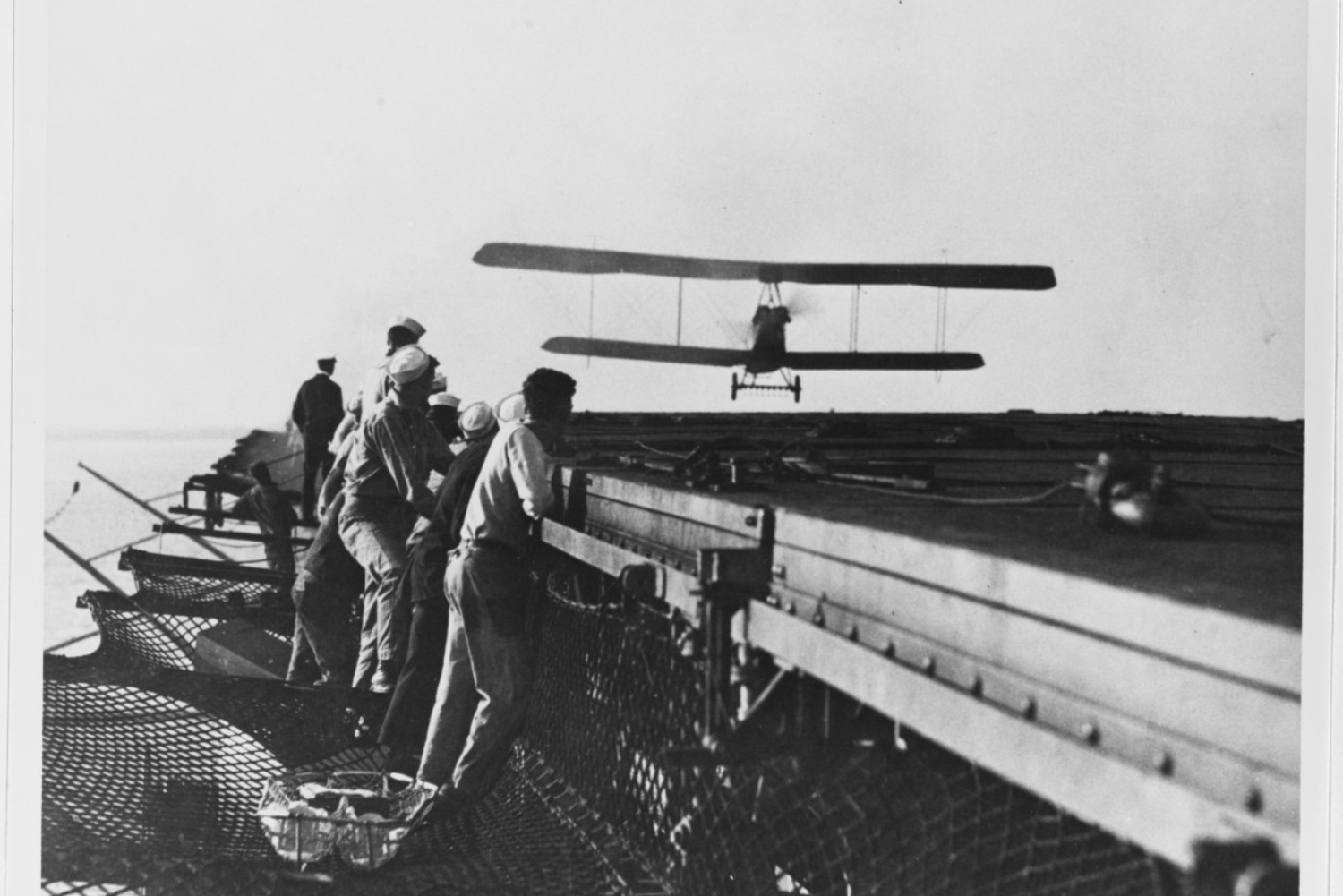 Men on USS Langley aircraft carrier watching plane takeoff